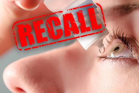 A close-up of a woman putting eye drops in her eye. Over the picture is the word “Recall” in big, red letters