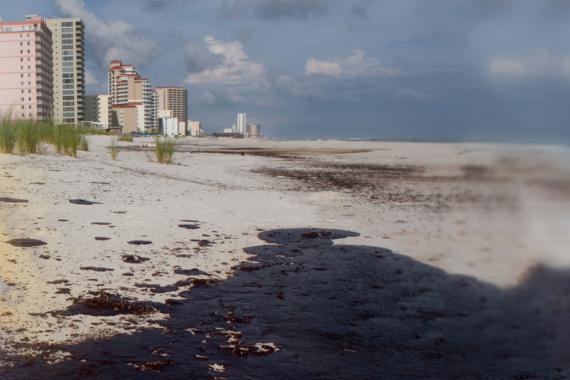 A blended image of a map and buildings along a beach that is polluted from an oil spill. 